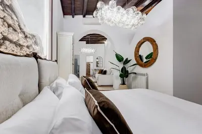 a bedroom with a white bed and a chandelier at NEW ROMAN Apartment - Rome Dream Home in Rome