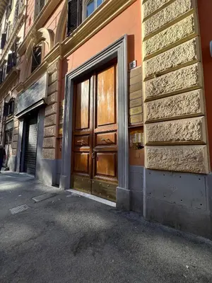 a building with wooden doors on the side of a street at Emilia's home in Rome
