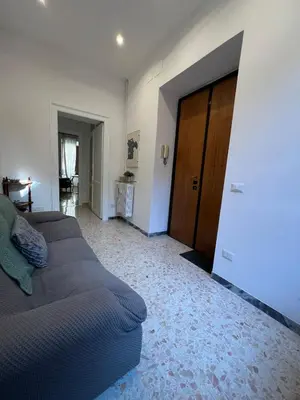 a living room with two beds and a wooden door at Emilia's home in Rome