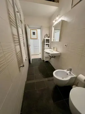 a white bathroom with a sink and a toilet at Emilia's home in Rome