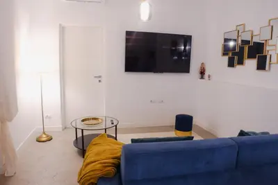 a living room with a blue couch and a tv at Lussuosa Casa nel cuore di Trastevere in Rome