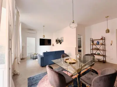 a living room with a blue couch and a glass table at Lussuosa Casa nel cuore di Trastevere in Rome