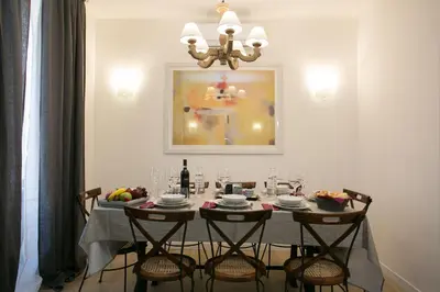a dining room with a table with chairs and a painting at Thebestinrome Piazza del Popolo - Vico in Rome