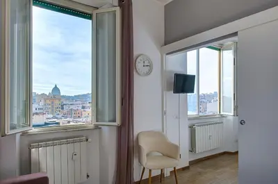 a room with a window with a chair and a clock at Luxury view on St Peter Basilica in Rome