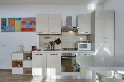 a kitchen with white cabinets and a sink and a microwave at Luxury view on St Peter Basilica in Rome