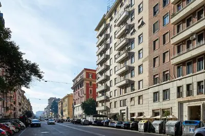 a city street with cars parked next to tall buildings at Luxury view on St Peter Basilica in Rome