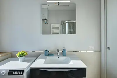 a bathroom with a white sink and a mirror at Luxury view on St Peter Basilica in Rome