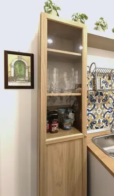 a cupboard with glasses in it next to a sink at San Peter Vatican City quiet and lovely apartment in Rome