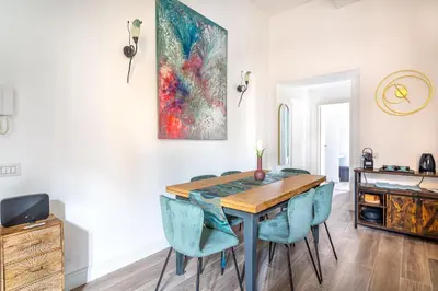 a dining room with a table and blue chairs at iFlat Brand New & Modern Central Station apt in Rome