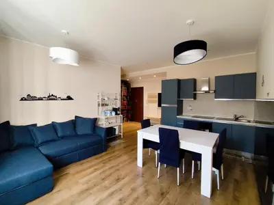 a living room with a blue couch and a table at La Casetta Battistini in Rome
