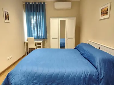 a bedroom with a blue bed in a room at La Casetta Battistini in Rome