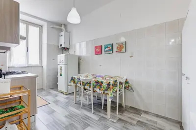 a kitchen with a table and a refrigerator at Re Di Roma Retreat in Rome