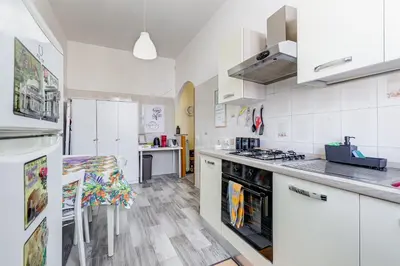 a kitchen with white cabinets and a stove top oven at Re Di Roma Retreat in Rome