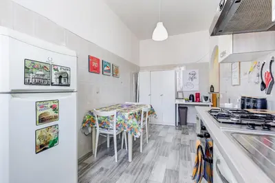 a white kitchen with a table and a stove at Re Di Roma Retreat in Rome