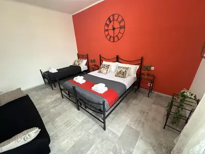 a bedroom with two beds and a red wall at Re Di Roma Retreat in Rome