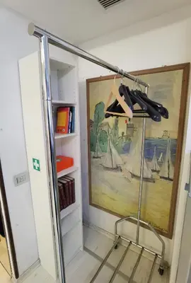 a clothes rack in a room with a painting at Ballarin Studio Apartment for Business Travels and Holidays in Rome
