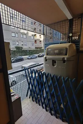 a grill on a balcony with a view of a street at Ballarin Studio Apartment for Business Travels and Holidays in Rome