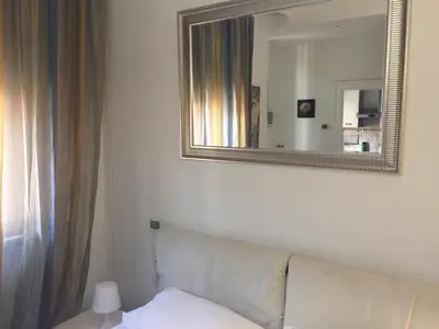 a living room with a white couch and a mirror at Angelo ai Musei Vaticani studio in Rome