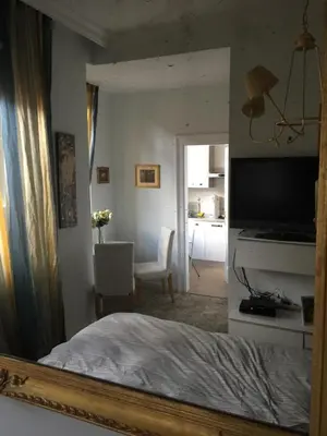 a mirror reflection of a bedroom with a bed and a chair at Angelo ai Musei Vaticani studio in Rome