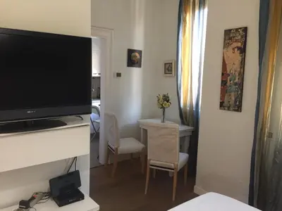 a living room with a television and a table with chairs at Angelo ai Musei Vaticani studio in Rome