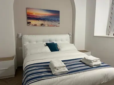a white bed with two towels on top of it at Munsi Vatican House in Rome