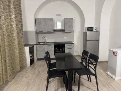 a kitchen with a black dining table and chairs at Munsi Vatican House in Rome
