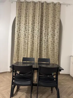 a black table and chairs in front of a curtain at Munsi Vatican House in Rome