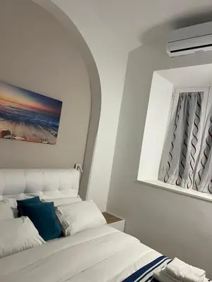 a white bedroom with a bed and a mirror at Munsi Vatican House in Rome
