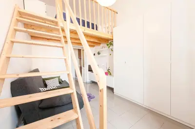 a wooden staircase in a room with white cabinets at Cozy House near Termini Station - San Lorenzo in Rome