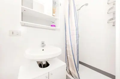a white bathroom with a sink and a shower at Cozy House near Termini Station - San Lorenzo in Rome