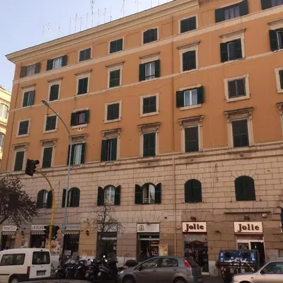 a large orange building with windows in a city at Cozy House near Termini Station - San Lorenzo in Rome