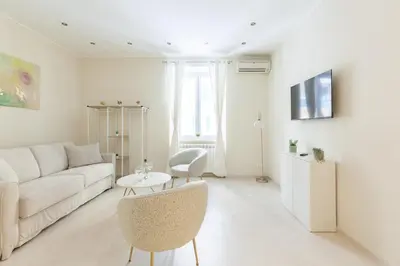a white living room with a couch and a table at Hostly-The Happya Charme Suite in Rome