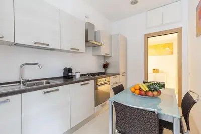 a kitchen with a table with a bowl of fruit on it at Hostly-The Happya Charme Suite in Rome