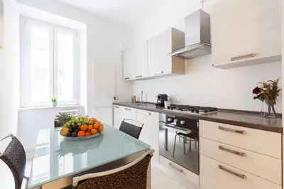a kitchen with a table with a bowl of fruit on it at Hostly-The Happya Charme Suite in Rome