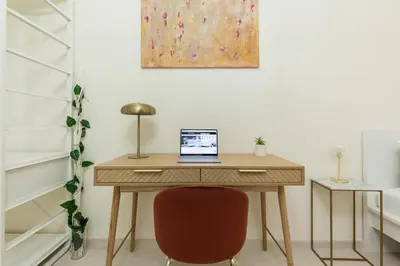 a desk with a laptop computer sitting on top of it at Hostly-The Happya Charme Suite in Rome