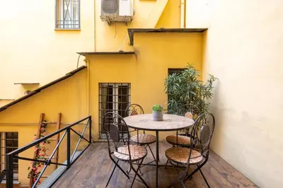 a table and chairs on a balcony with a building at Ombrellari Secret Terrace in Rome