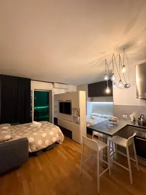a bedroom with a bed and a kitchen with a table at Modern Loft Private in Rome