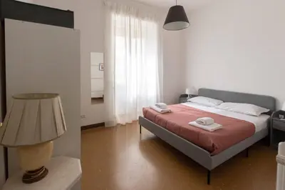 a bedroom with a bed and a lamp and a room at Domus Erasmo in Rome