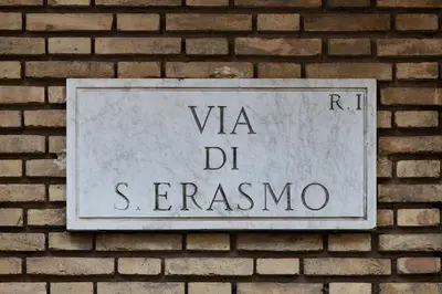 a sign on the side of a brick wall at Domus Erasmo in Rome