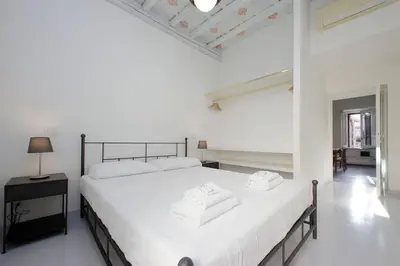a white bedroom with a large bed with white sheets at Monti Charming Apt Boschetto in Rome