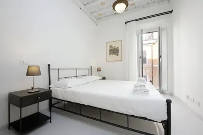 a white bedroom with a black bed and a window at Monti Charming Apt Boschetto in Rome