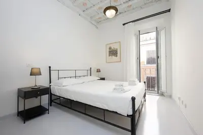 a white bedroom with a bed and a window at Monti Charming Apt Boschetto in Rome