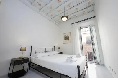 a white bedroom with a bed and a window at Monti Charming Apt Boschetto in Rome
