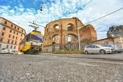 a train on the tracks in front of a building at Hotel Giolitti Smart in Rome