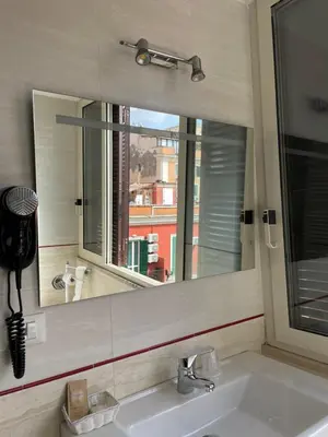a bathroom with a mirror and a sink with a window at Hotel Giolitti Smart in Rome