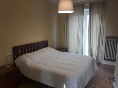 a bedroom with a white bed and a large window at Gallia in Rome