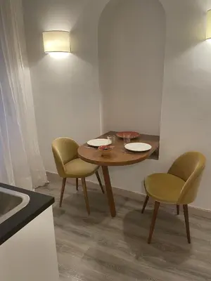 a kitchen with white walls and a wooden floor at Centro Roma Cortile - LOCAPPART in Rome