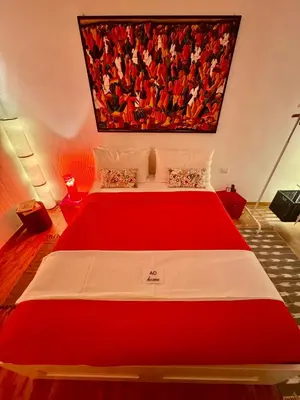 a red and white bed in a room with a painting on the wall at Ao Apartment in Rome