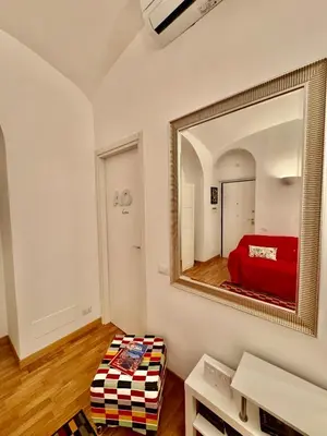 a mirror on a wall with a bed in a room at Ao Apartment in Rome