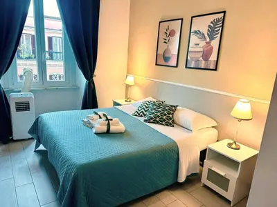 a hotel room with a bed with a blue blanket at Girasole Guesthouse in Rome